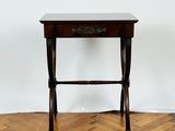 a small table with a drawer on it on a parquet floor