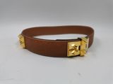 un gros plan sur une ceinture en cuir marron avec des boucles dorées