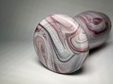 two pink and white marbles sitting on top of a white surface
