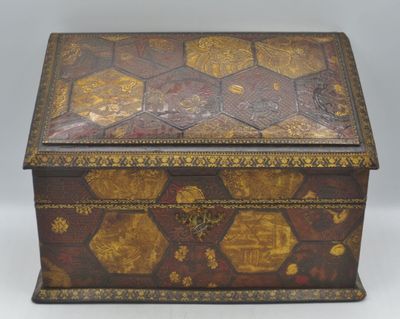 an old wooden box with gold and black designs on it