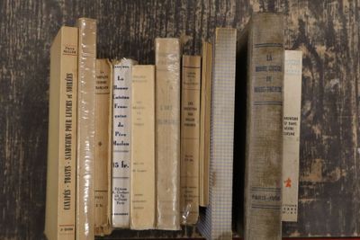 de nombreux livres posés sur une étagère posée sur une table