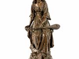 statue en bronze représentant une femme assise sur un tabouret, un livre sur les genoux