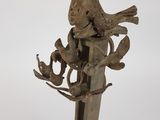statue of a bird on a branch with a bird on it ' s back