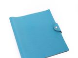 un cahier bleu avec un bouton sur la couverture