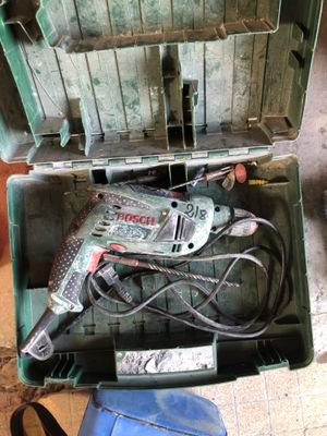 un outil dans une boîte verte, muni d'un cordon d'alimentation