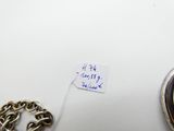 une photo représentant une horloge et une chaîne posées sur une table