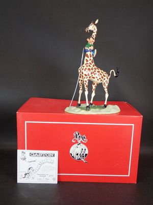 une figurine de girafe posée sur une boîte rouge