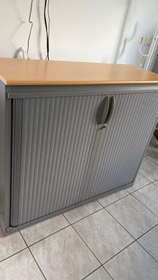 une armoire grise avec un plateau en bois, posée sur un sol carrelé