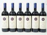 six bouteilles de vin sont alignées sur une surface blanche