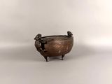 an antique bronze bowl with two birds on it on a white surface