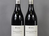 two bottles of wine sitting on top of a table next to each other