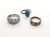 trois bagues et une bague ornée d'une pierre turquoise sur un fond blanc