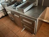 stainless steel counter top in a commercial kitchen with a microwave and oven