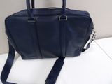 navy blue leather handbag with shoulder strap on a white surface