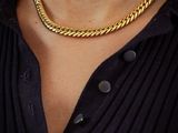 the man is wearing a black shirt and a gold chain necklace