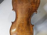 a violin that is sitting on a table next to a bag