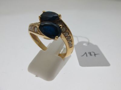 une image d'une bague en or avec une pierre bleue et des diamants