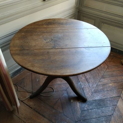 une table avec un plateau en bois posée sur un parquet