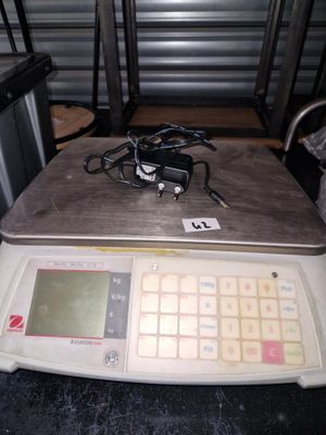 une photo d'une balance posée sur une table, sur laquelle se trouve un ordinateur portable