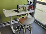 une machine à coudre posée sur une table devant une fenêtre