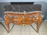 a marble topped chest of drawers on a tiled floor