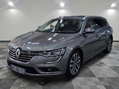 the grey car is parked on a checkered floor in the garage