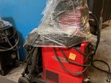 a picture of a red machine in a room with a blue wall