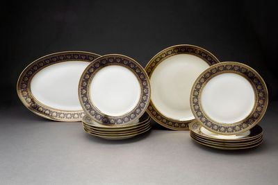 cinq assiettes ornées de bordures dorées et d'un motif noir et blanc