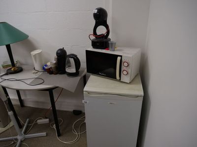 une petite table sur laquelle est posé un micro-ondes