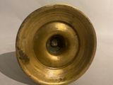 a gold vase that is sitting on a white surface