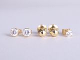 a set of three gold stud earrings with diamonds on a white background