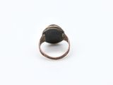 a close up of a ring with a black stone on it