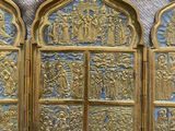 three gold and blue stained glass panels with religious scenes on them