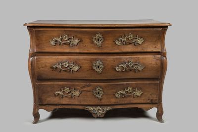 une commode ancienne dont les tiroirs sont ornés de sculptures élaborées
