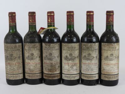six bouteilles de vin sont alignées sur une surface blanche