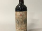 une vieille bouteille de vin posée sur une table blanche