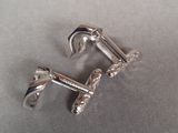 pair of silver colored cufflinks on a gray surface