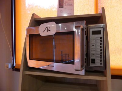 un micro-ondes posé sur une étagère, avec une étiquette de prix dessus