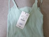 a green top that has a price tag on it