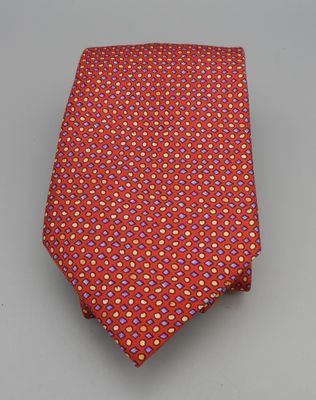 Hermès Paris, Cravate en soie imprimée sur fond rouge.