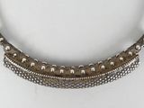 a close up of a silver necklace on a white surface