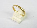 une bague en or posée sur un bloc de marbre blanc
