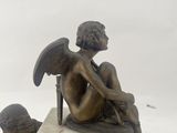 a statue of an angel sitting on top of a clock