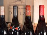 several bottles of red wine are lined up on a table