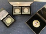 three gold coins are in a black box on a blue surface