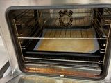 a silver oven with a baking tray inside of it