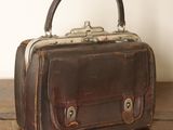 un petit sac marron posé sur une table en bois