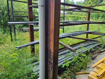 un tas de bois posé par terre près d'une clôture