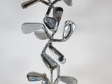 a metal sculpture of a golf club on a stand