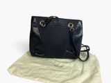 Le sac à main noir est posé sur le tissu, à côté du sac.